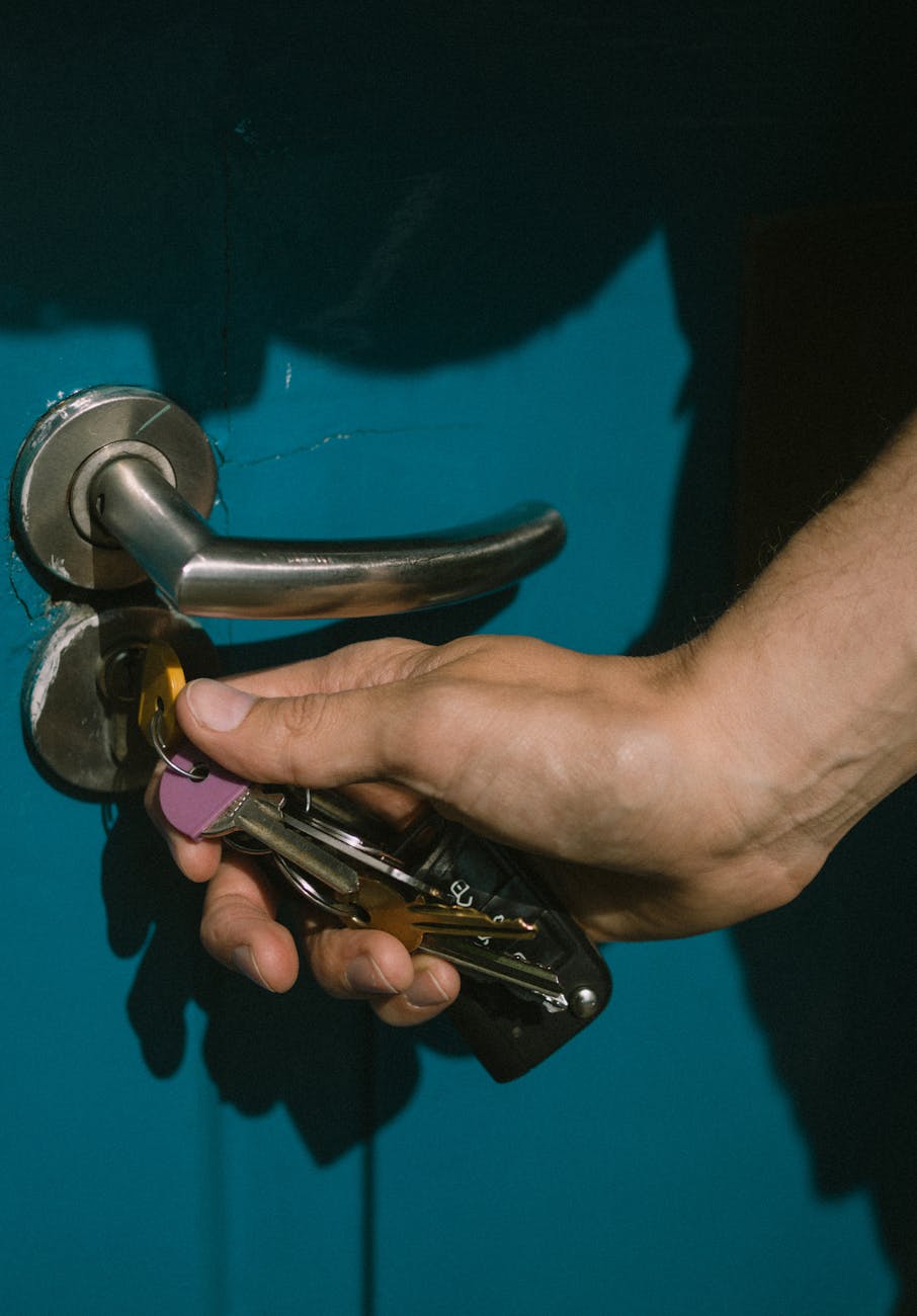 A person holding a set of keys in front of a door handle, preparing to unlock the door to virtual restaurant services.