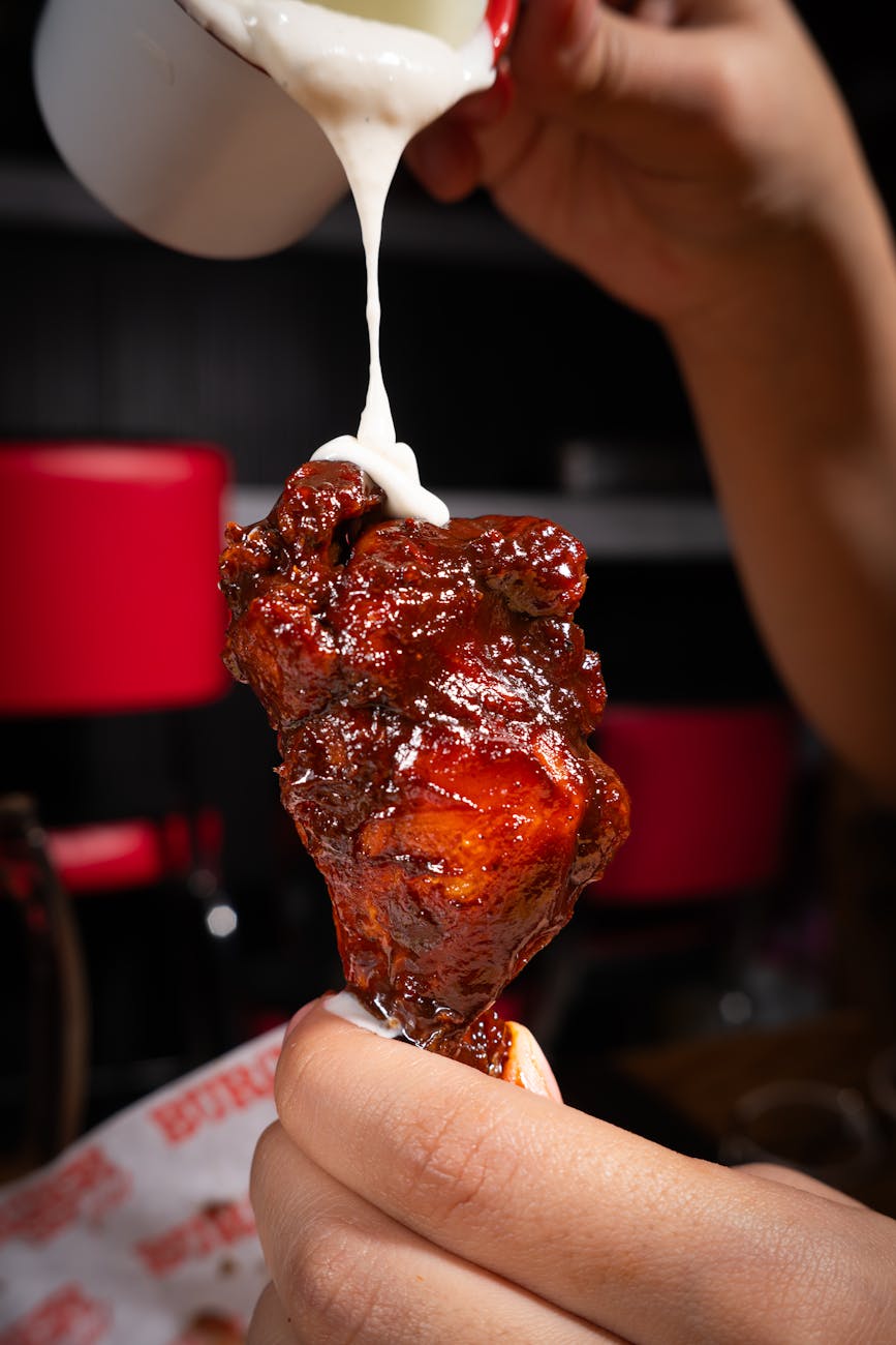 close up of spicy chicken wing with dipping sauce