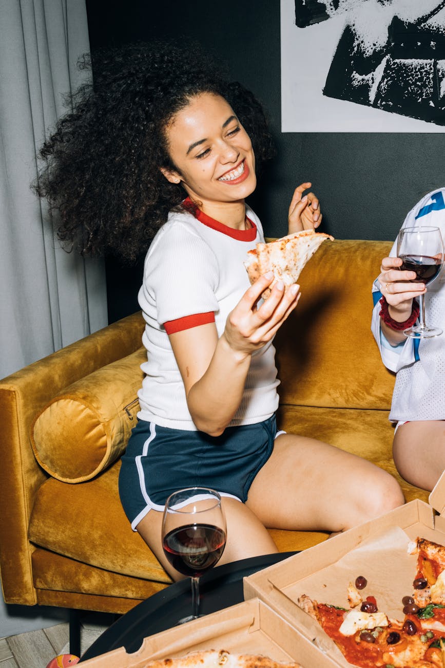 young woman having fun while eating pizza